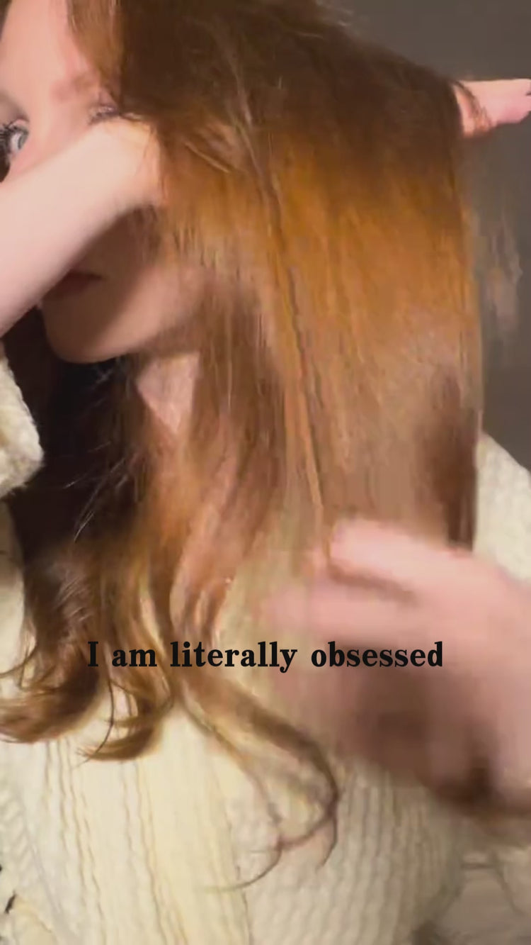 A woman with long auburn hair shows her smooth, shiny hair after using the MASIL 8 Seconds Salon Hair Mask. The video demonstrates the mask transforming from a clear liquid into a white cream when mixed with water, then being applied to the ends of wet hair, followed by a display of the gray bottle packaging with a pink number 8 in multiple sizes.